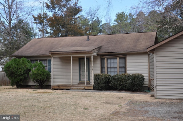 ranch-style home with a shingled roof and a front yard