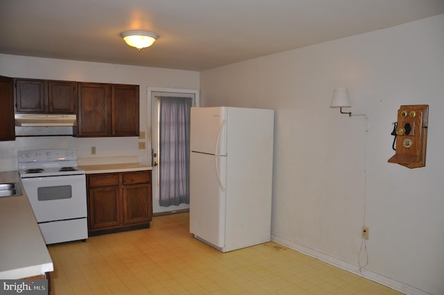 kitchen featuring light countertops, white appliances, light floors, and under cabinet range hood