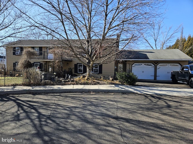 view of front of property with a garage, fence, and a balcony