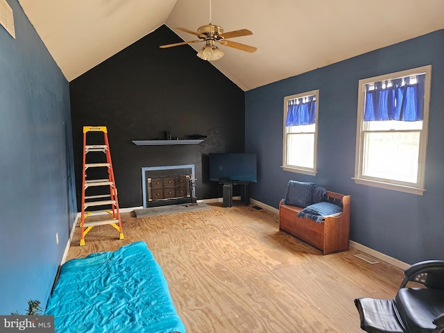 unfurnished living room featuring wood finished floors, a ceiling fan, visible vents, vaulted ceiling, and baseboards