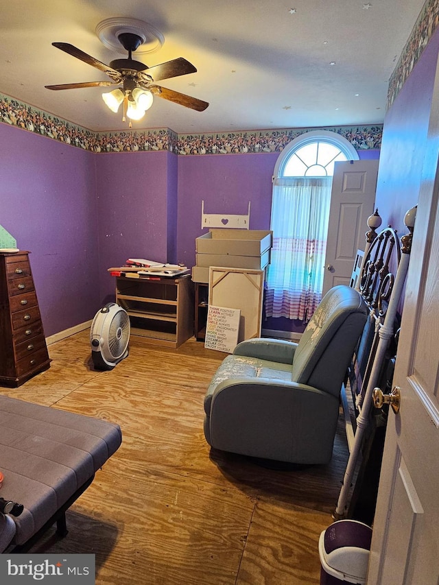 bedroom with ceiling fan, wood finished floors, and baseboards