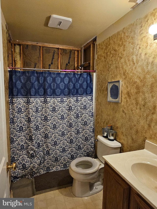 bathroom featuring a shower with shower curtain, vanity, and toilet