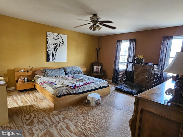 bedroom with multiple windows, baseboards, and a ceiling fan