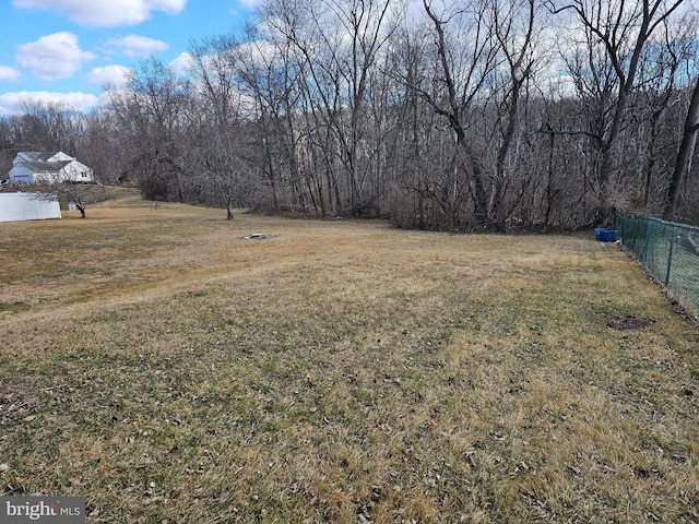 view of yard featuring fence and a view of trees