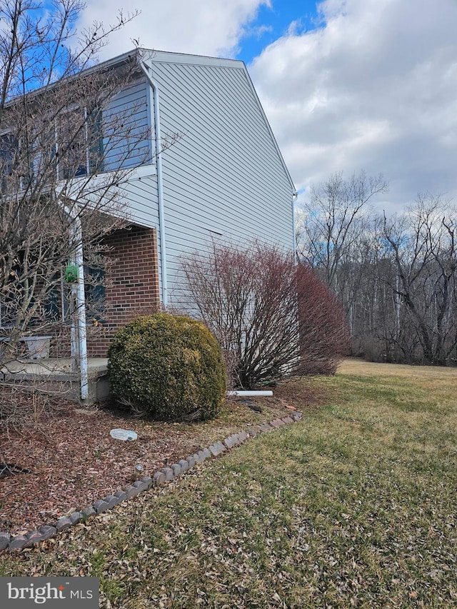 view of side of home featuring a yard and brick siding