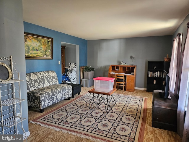 living area featuring baseboards and wood finished floors