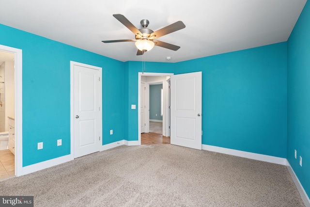 unfurnished bedroom featuring connected bathroom, carpet, ceiling fan, and baseboards