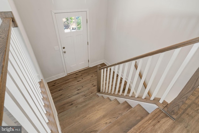 entryway featuring stairs, wood finished floors, and baseboards