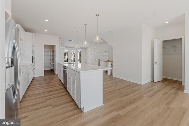 kitchen with recessed lighting, stainless steel appliances, white cabinets, light wood-style floors, and light countertops