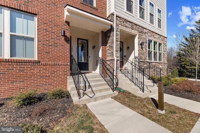 doorway to property featuring stone siding and brick siding