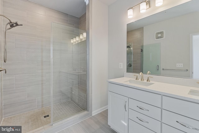 full bath featuring double vanity, a shower stall, and a sink