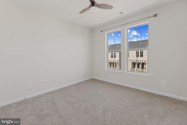 unfurnished room with ceiling fan, carpet, visible vents, and baseboards