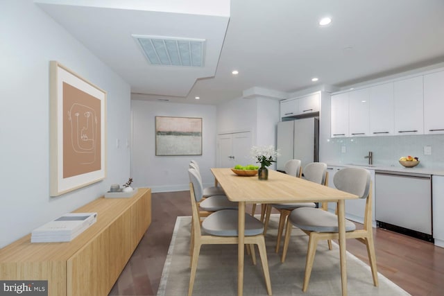 dining room with wood finished floors, recessed lighting, visible vents, and baseboards