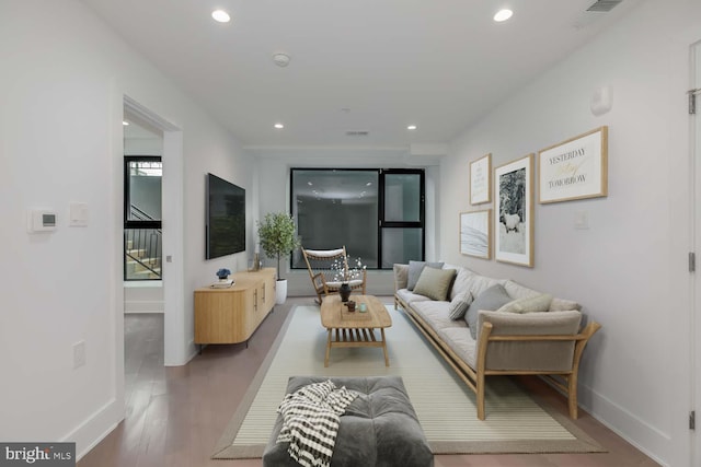 living room featuring recessed lighting, baseboards, and wood finished floors