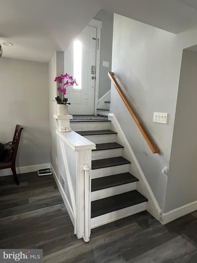 staircase with baseboards and wood finished floors