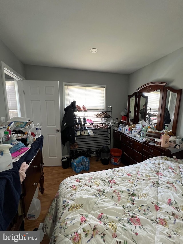 bedroom with multiple windows and wood finished floors