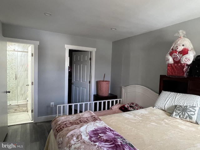 bedroom with baseboards, wood finished floors, and ensuite bathroom