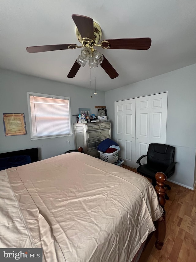 bedroom featuring ceiling fan, a closet, baseboards, and wood finished floors