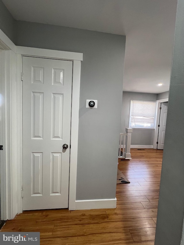 hall featuring baseboards and wood finished floors