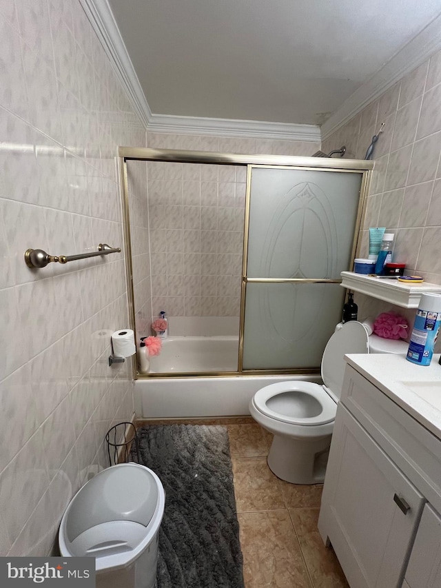 full bath featuring bath / shower combo with glass door, toilet, crown molding, vanity, and tile walls