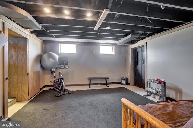 exercise room with baseboards and carpet flooring