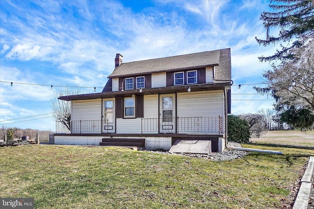 rear view of property featuring a lawn, covered porch, and a chimney