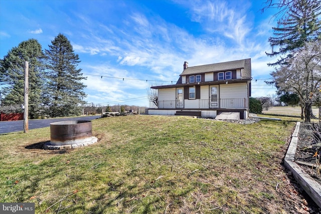 rear view of property with a lawn and a chimney