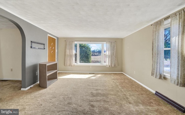 interior space featuring arched walkways, a textured ceiling, and baseboards