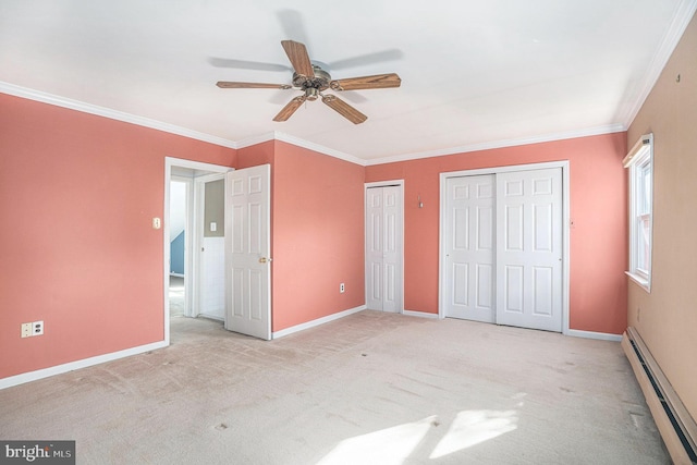 unfurnished bedroom featuring a baseboard radiator, baseboards, carpet, two closets, and crown molding