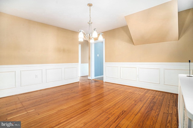 unfurnished dining area featuring hardwood / wood-style floors and a notable chandelier