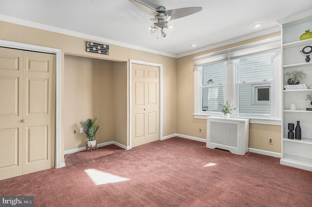 unfurnished bedroom featuring carpet, two closets, ornamental molding, ceiling fan, and baseboards