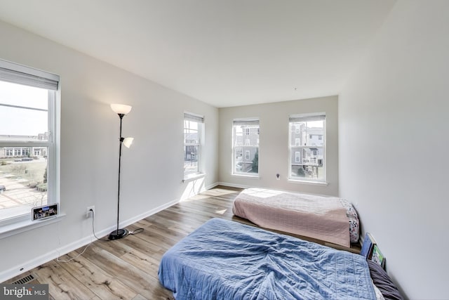 bedroom with light wood-style flooring and baseboards