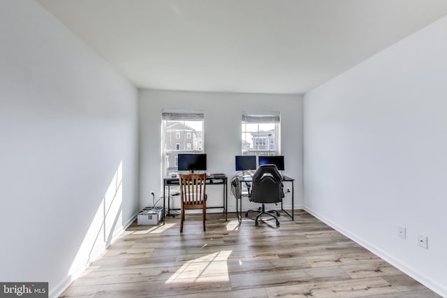 home office with baseboards and wood finished floors