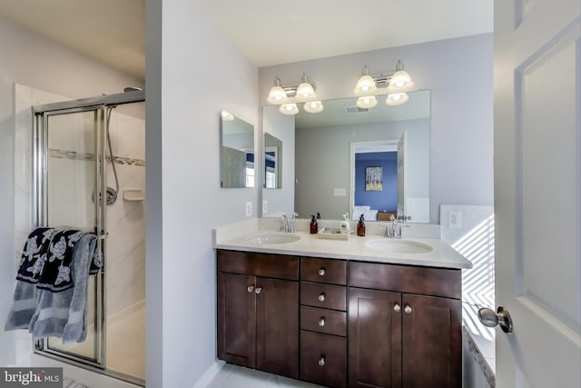 bathroom featuring double vanity, visible vents, a shower stall, and a sink