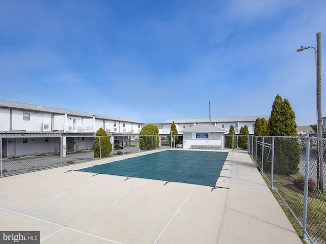 community pool with a residential view, a patio, and fence