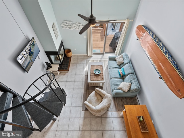 tiled living room featuring baseboards and ceiling fan