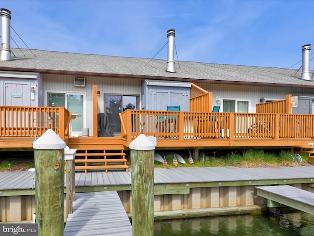 rear view of property featuring a shingled roof and a wooden deck