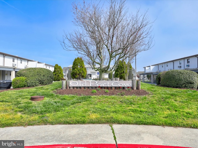 community sign featuring a lawn and a residential view