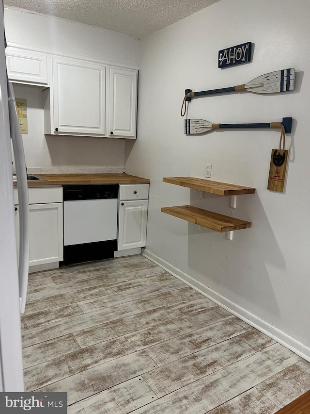 kitchen with white cabinets, a textured ceiling, light wood-style flooring, and white dishwasher