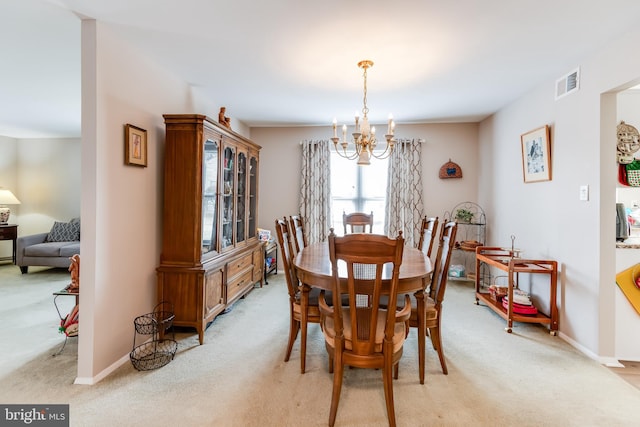 dining space with visible vents, light carpet, a notable chandelier, and baseboards