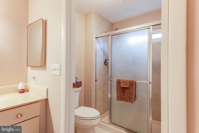 full bath featuring a stall shower, toilet, and vanity