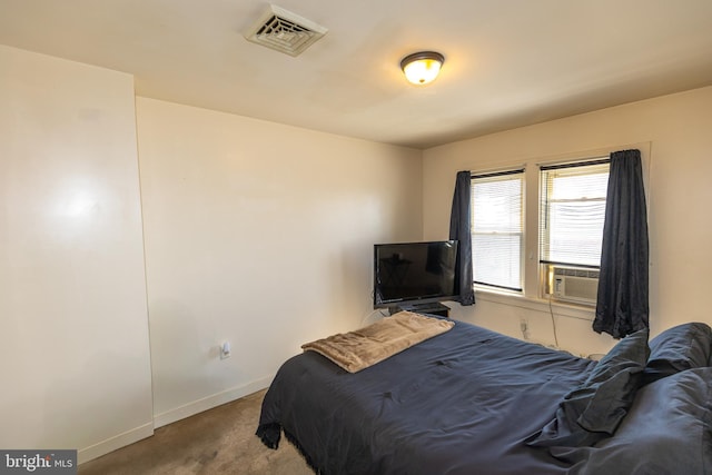 bedroom with cooling unit, baseboards, visible vents, and carpet flooring