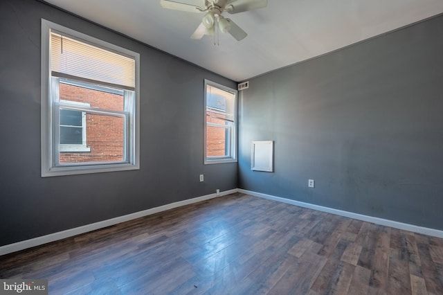 unfurnished room with dark wood finished floors, baseboards, and ceiling fan