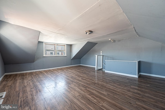 additional living space with baseboards, lofted ceiling, and wood finished floors