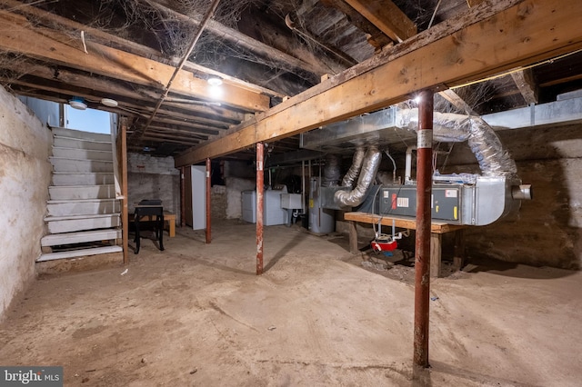 unfinished below grade area with stairs, washer / dryer, water heater, and a sink