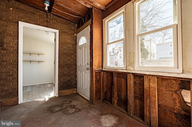 entryway with concrete floors and brick wall