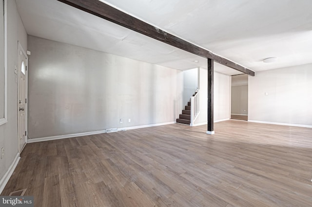 finished basement featuring stairs, wood finished floors, and baseboards