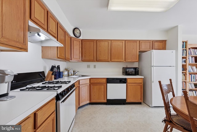 kitchen with under cabinet range hood, a sink, white appliances, light countertops, and light floors