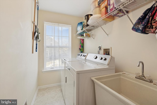 laundry room featuring laundry area, plenty of natural light, separate washer and dryer, and a sink