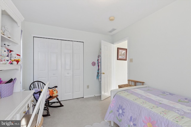 bedroom featuring visible vents, light carpet, and a closet